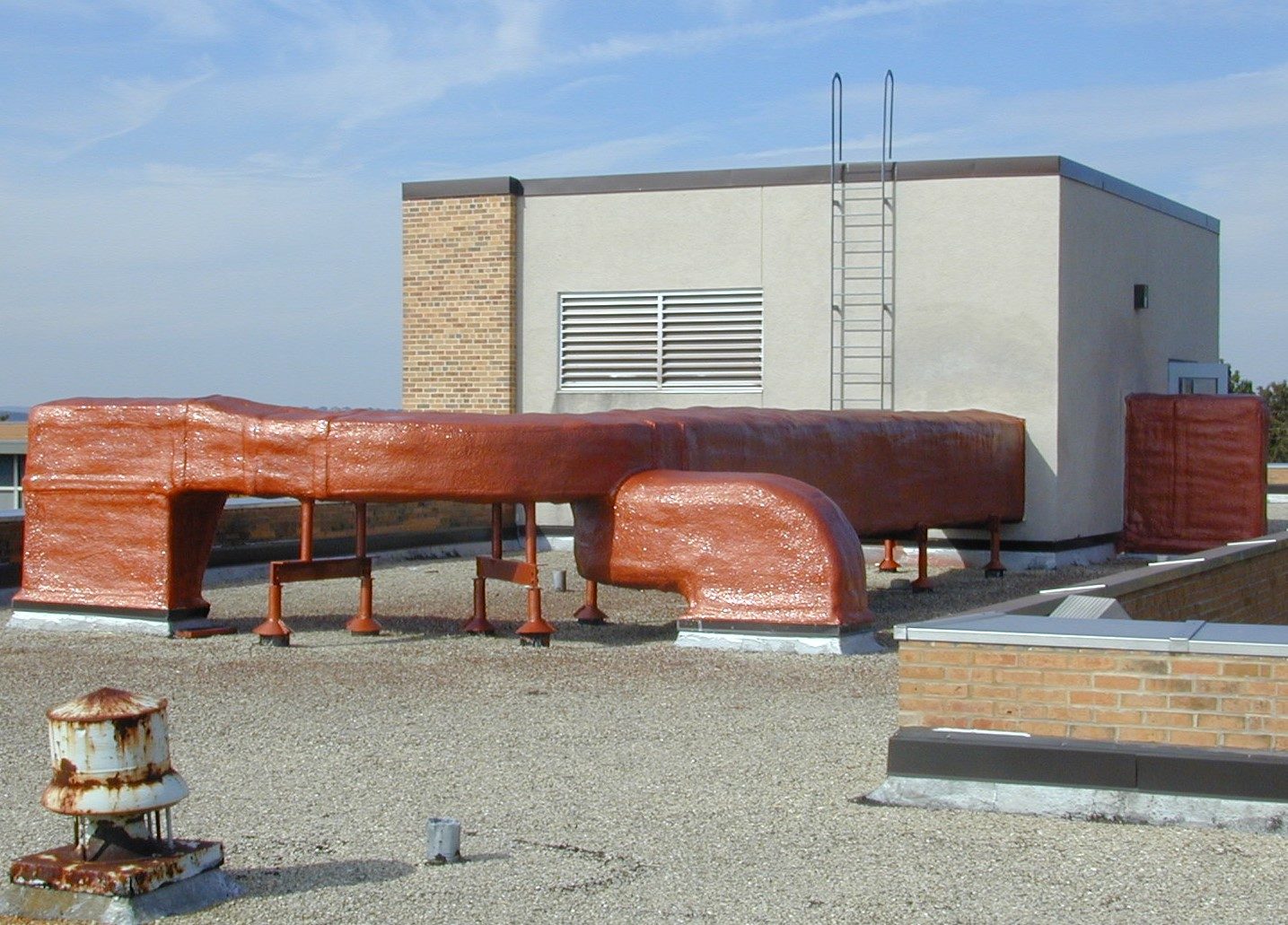 Applicator spraying an RV roof waterproofing membrane